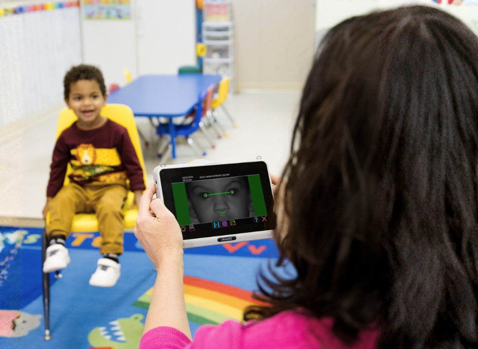 Child using a wheelchair with a tablet in a classroom setting