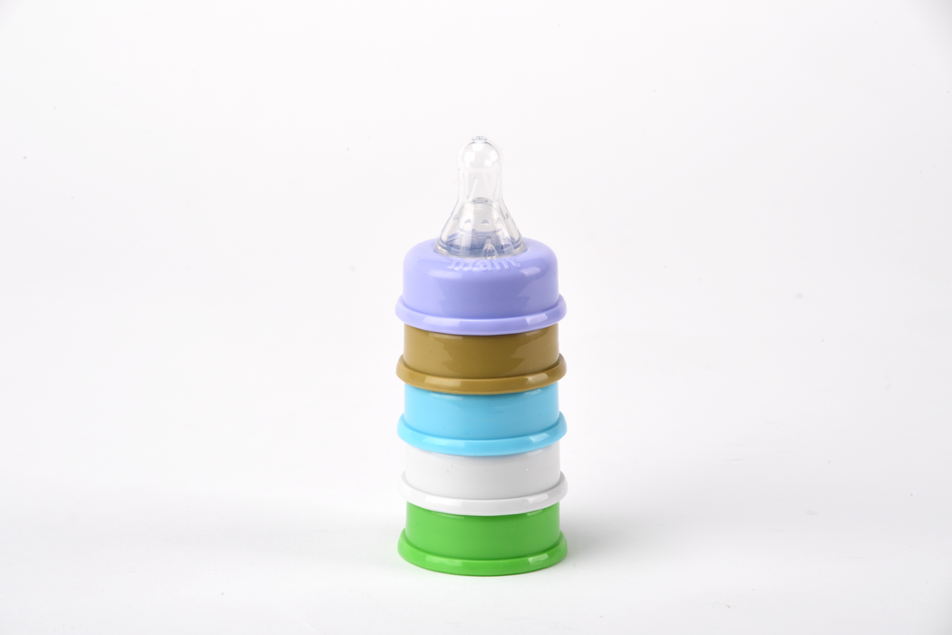 Stack of colorful baby bottle nipples on a white background