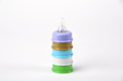 Stack of colorful baby bottle nipples on a white background